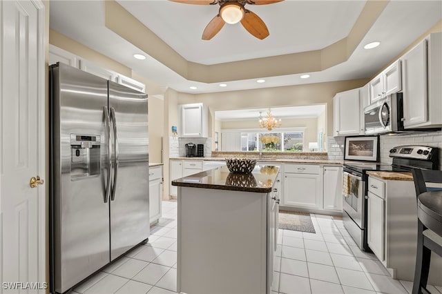 kitchen featuring tasteful backsplash, a center island, white cabinets, and appliances with stainless steel finishes