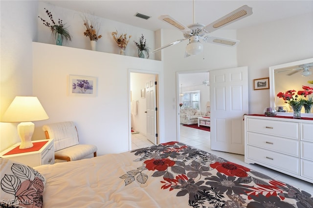 tiled bedroom featuring a towering ceiling, ceiling fan, and ensuite bathroom