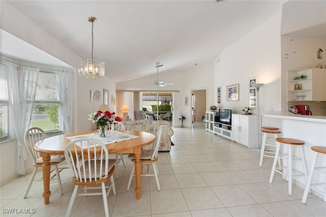 dining area with ceiling fan with notable chandelier, light tile patterned flooring, and lofted ceiling