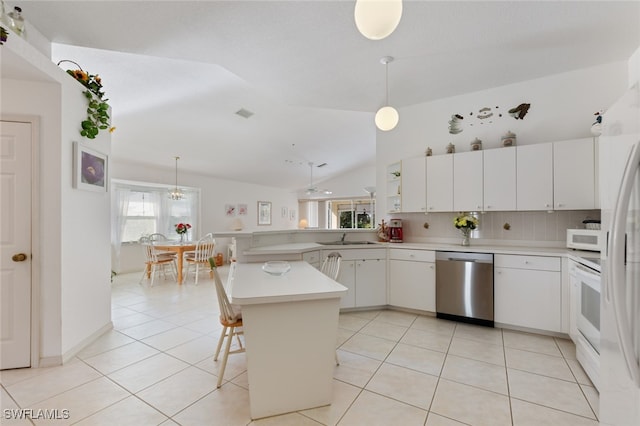 kitchen with a kitchen breakfast bar, lofted ceiling, white cabinets, and white appliances