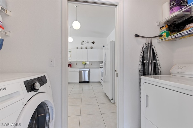 clothes washing area with washer and clothes dryer and light tile patterned floors