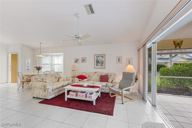 living room with ceiling fan with notable chandelier and light tile patterned floors