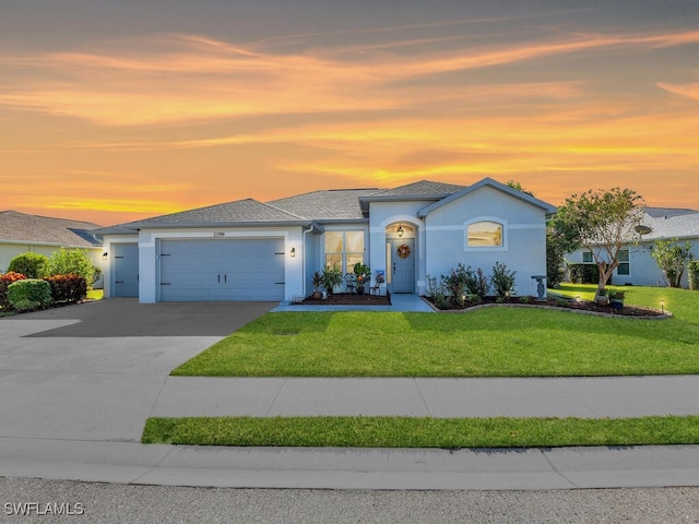 view of front of home featuring a garage and a yard