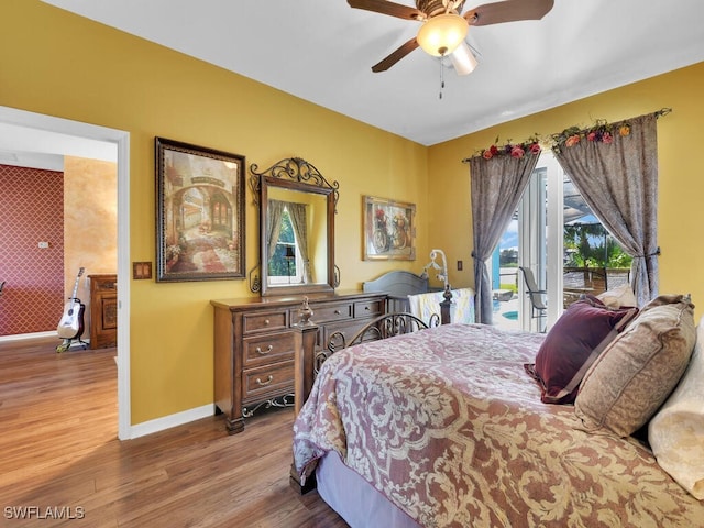 bedroom featuring access to exterior, hardwood / wood-style floors, and ceiling fan