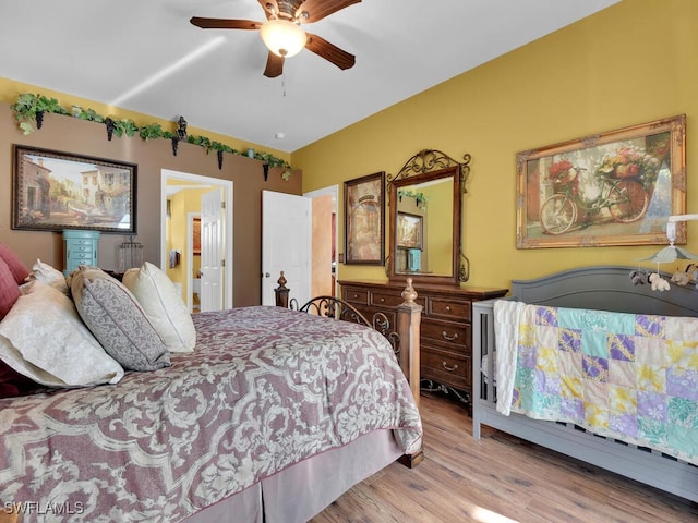 bedroom featuring ensuite bathroom, ceiling fan, and light wood-type flooring