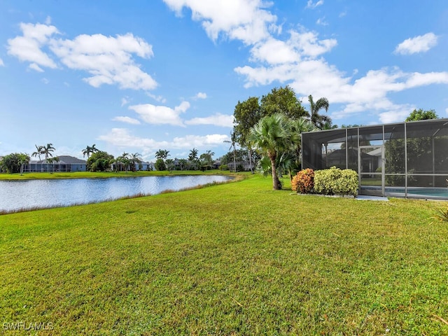 view of yard with a water view and a lanai