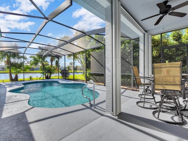 view of pool featuring a patio area, a water view, a lanai, and ceiling fan