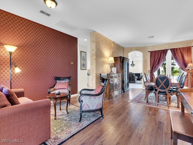 living room with ornate columns and dark wood-type flooring