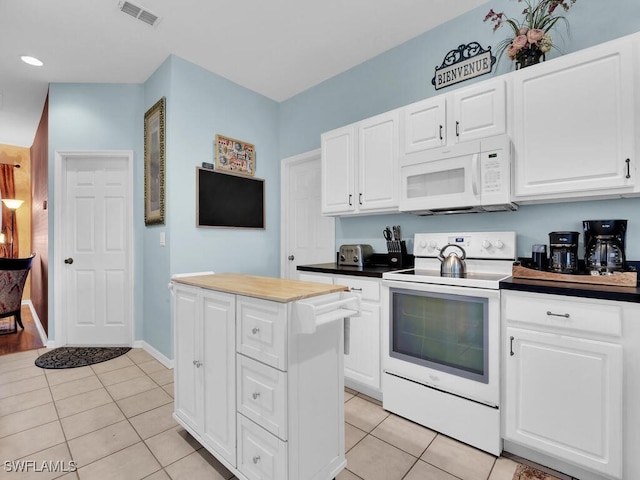 kitchen featuring white cabinetry, light tile patterned floors, white appliances, and a kitchen island