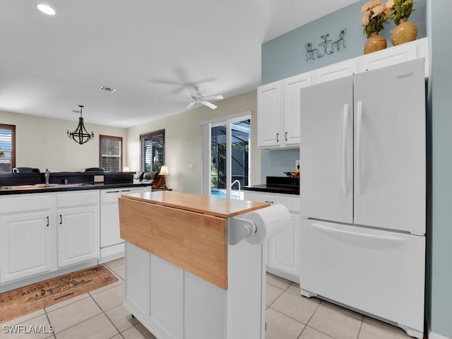 kitchen featuring white appliances, a healthy amount of sunlight, white cabinetry, and a kitchen island