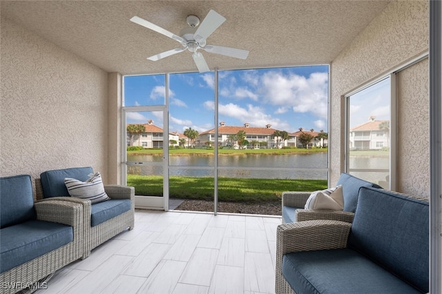 sunroom / solarium with a water view and ceiling fan