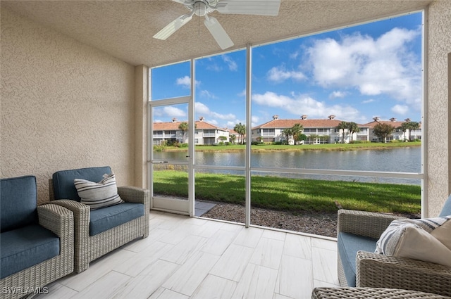 sunroom featuring a water view and ceiling fan