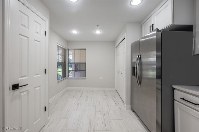 kitchen with white cabinets and stainless steel fridge