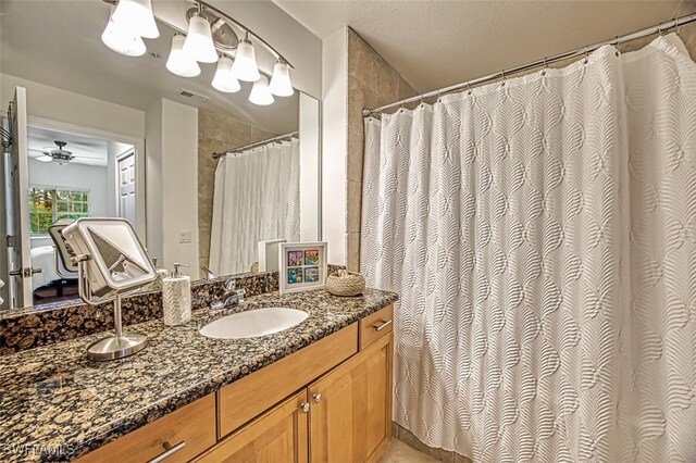 bathroom with vanity, a textured ceiling, curtained shower, and ceiling fan