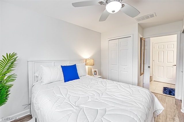 bedroom with light hardwood / wood-style flooring, a closet, and ceiling fan