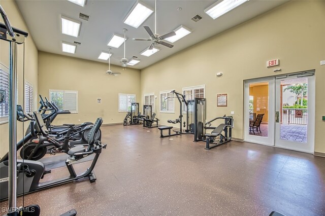 workout area featuring ceiling fan, a towering ceiling, and plenty of natural light