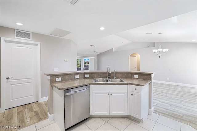 kitchen featuring stainless steel dishwasher, vaulted ceiling, sink, pendant lighting, and white cabinetry