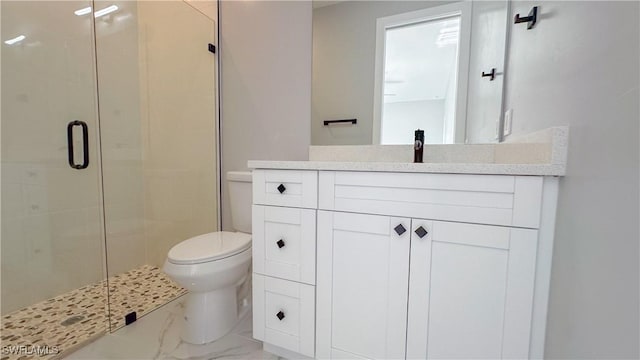 bathroom with vanity, toilet, and a shower with shower door