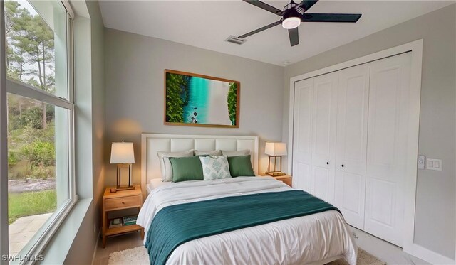 bedroom featuring multiple windows, a closet, and ceiling fan