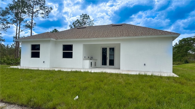 back of property with a yard and a patio area