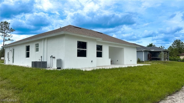 rear view of house featuring cooling unit, a yard, and a patio area