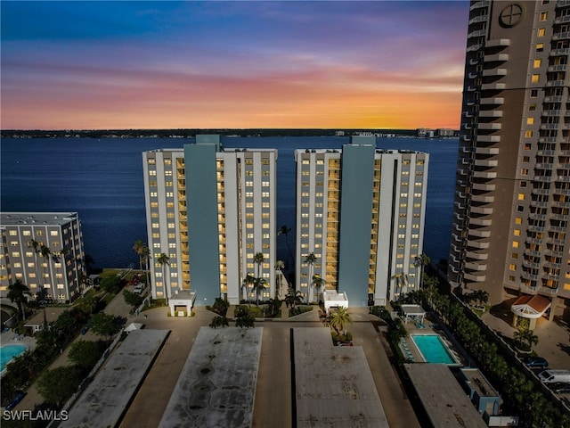 aerial view at dusk featuring a water view