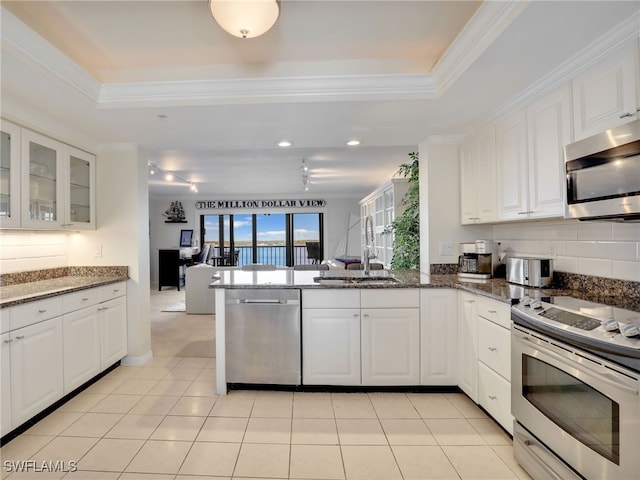 1925 Clifford St Unit 1202, Fort Myers, FL 33901 - kitchen with stainless steel appliances, a sink, a raised ceiling, a peninsula, and white cabinetry