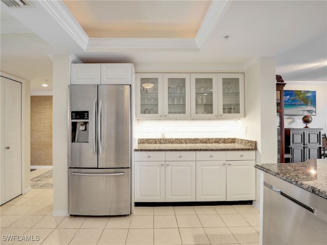 kitchen featuring dark stone counters, white cabinetry, appliances with stainless steel finishes, and light tile patterned floors