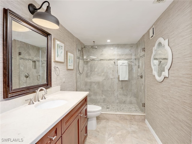 bathroom with toilet, vanity, and a shower with shower door