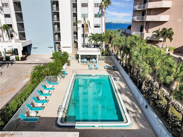 view of pool with a patio and a water view