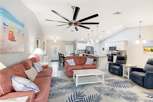 living room with ceiling fan with notable chandelier, sink, and vaulted ceiling