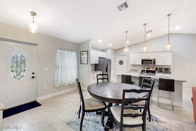 dining space featuring light hardwood / wood-style floors and lofted ceiling