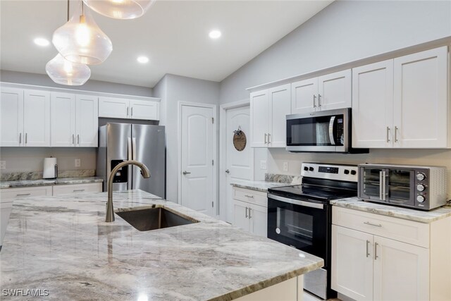 kitchen with pendant lighting, white cabinets, and stainless steel appliances