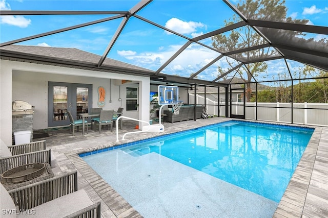 view of pool with glass enclosure and a patio