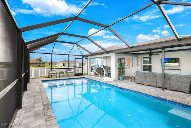 view of pool featuring an outdoor living space, ceiling fan, glass enclosure, and a patio area