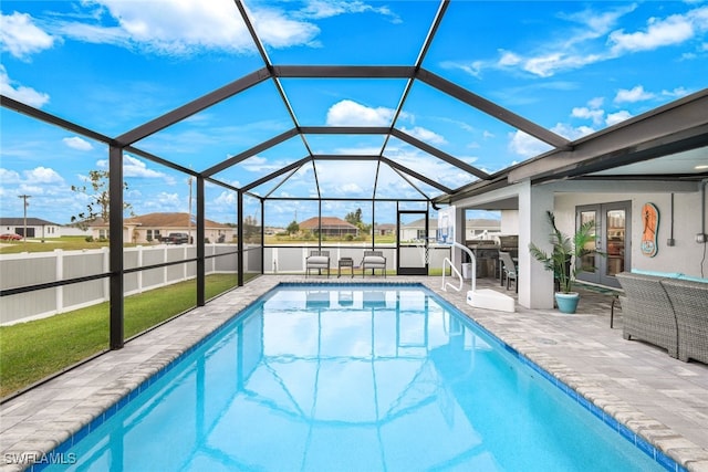 view of swimming pool with glass enclosure and a patio area