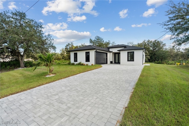 view of front of property with a front yard and a garage