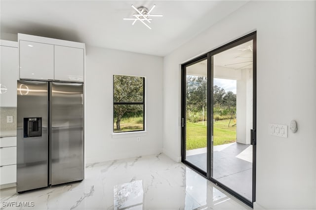 kitchen with white cabinets and stainless steel fridge with ice dispenser