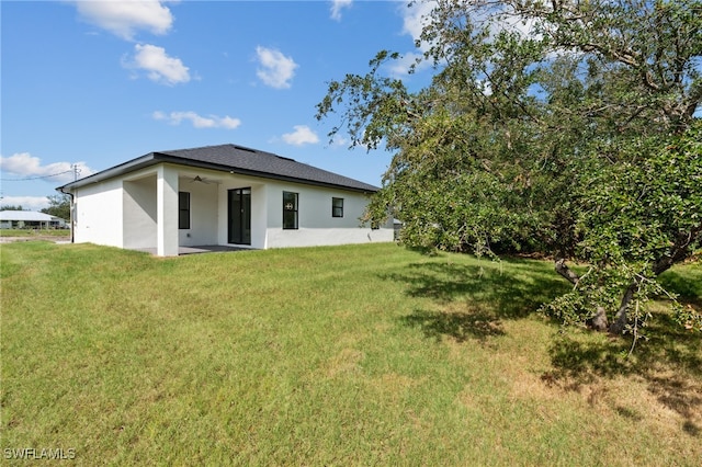 back of property featuring a lawn