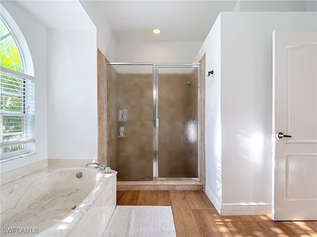 bathroom with shower with separate bathtub and hardwood / wood-style floors