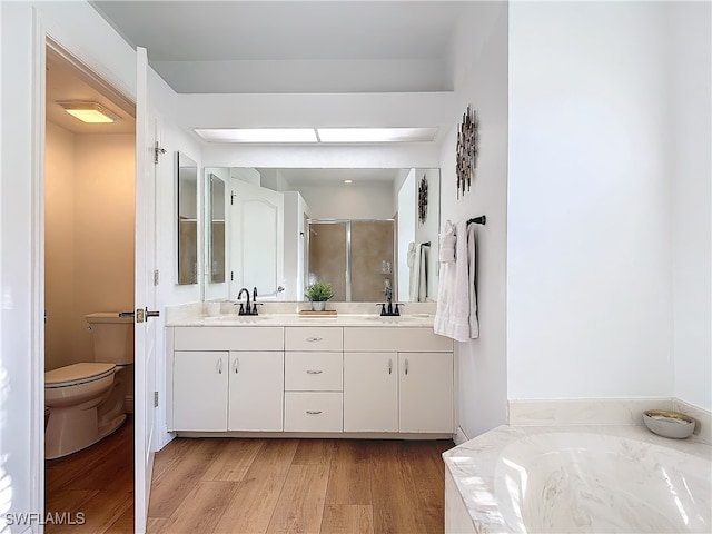 full bathroom featuring vanity, independent shower and bath, wood-type flooring, and toilet