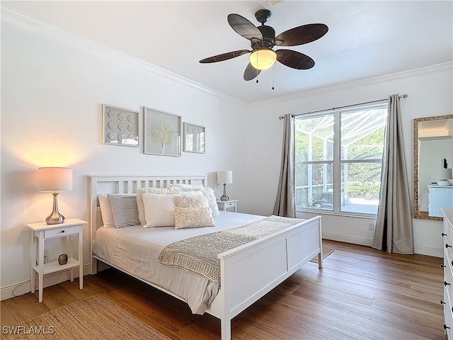 bedroom with ornamental molding, hardwood / wood-style floors, and ceiling fan