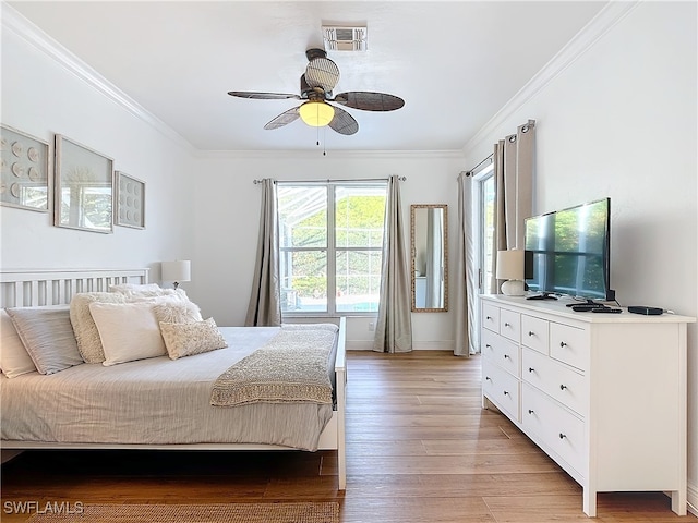 bedroom featuring ornamental molding, light wood-type flooring, and ceiling fan