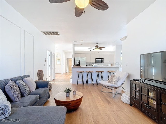 living room featuring light hardwood / wood-style floors and ceiling fan