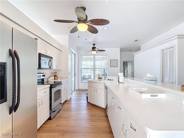 kitchen featuring appliances with stainless steel finishes, light wood-type flooring, and white cabinets