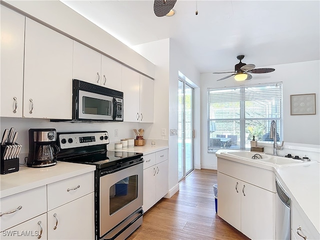 kitchen with sink, white cabinetry, stainless steel appliances, and light hardwood / wood-style floors