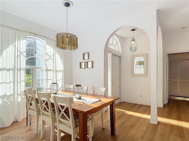 dining area featuring hardwood / wood-style flooring and an inviting chandelier