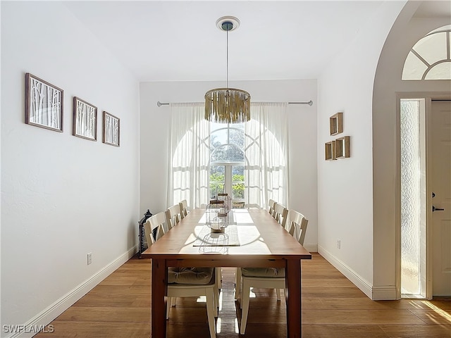 dining space featuring a notable chandelier and wood-type flooring