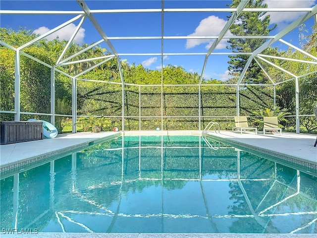 view of swimming pool featuring a patio area and a lanai