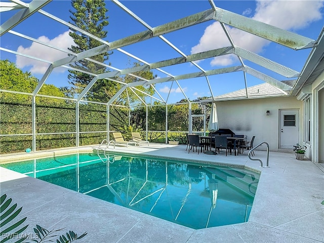 view of swimming pool with a patio area and a lanai